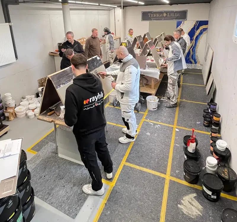Handwerker üben fugenlose Oberflächen an Musterplatten in der Terra Lilia Schulung