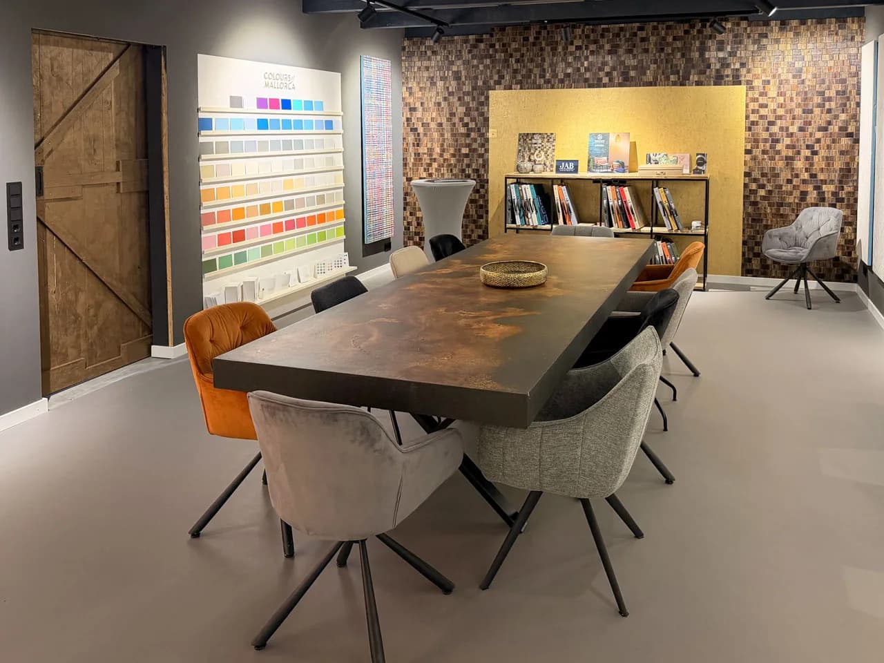 Beratungsbereich des Terra Lilia Showrooms mit Farbwand und altem Scheunentor